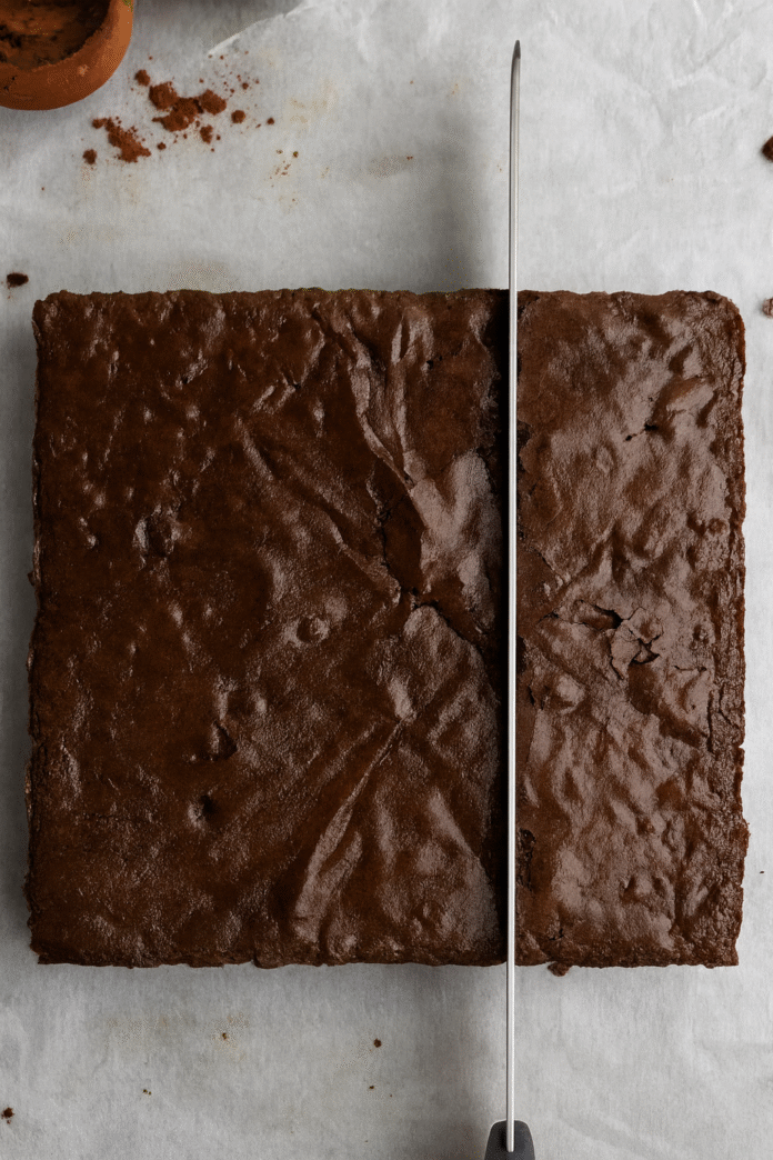 Otapanje tamne čokolade u toploj smjesi za brownie u metalnoj šerpi