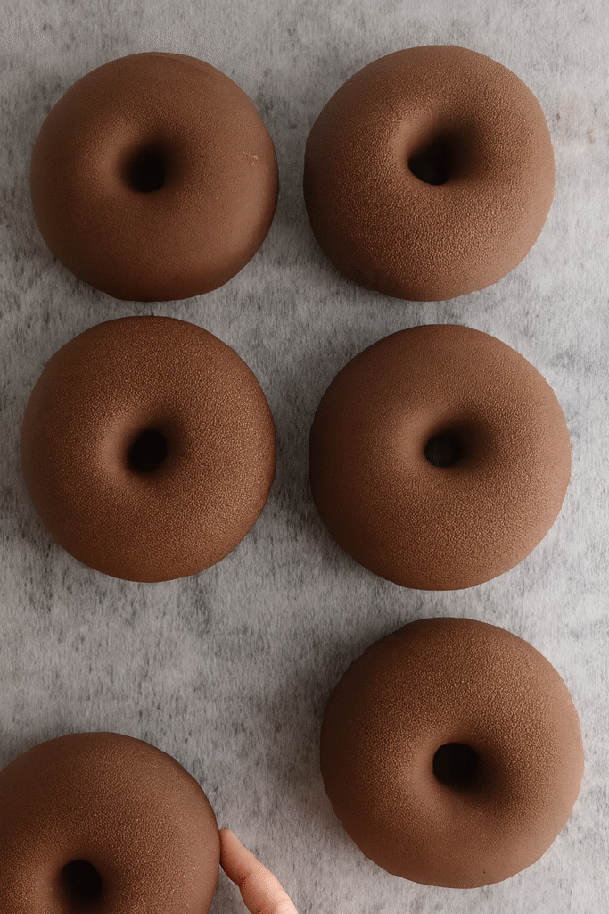 Čokoladni desert s hrskavom glazurom koji se lomi kašikom, otkrivajući bogatu i pjenastu kremu unutra.